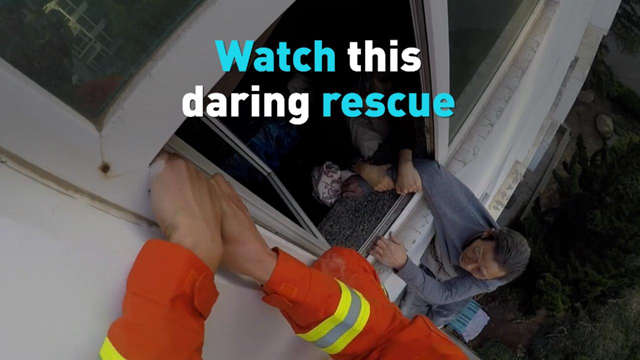 See firefighters rescue an elderly man hanging window in eastern China ...